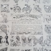 Black and white poster behind glass wth various drawings around the edges, showing animals, skulls, flowers, flags and hearts. In the centre is writing, mostly hard to read. Notably it says: Something For Everybody, by Good Time Charlie.Broadway Tattoo, Sydney